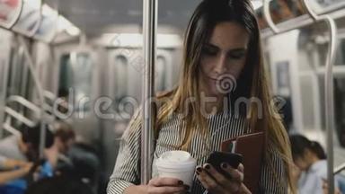 快乐轻松自信的博客女孩在地铁列车上使用智能<strong>手机音乐</strong>播放器应用程序微笑与咖啡杯。